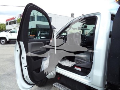 Truck cab interior with open passenger door showing Chevrolet Silverado 6500HD branding. Visible text on sticker inside door and dashboard; no additional readable labels.