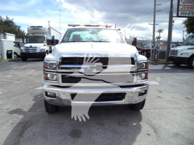 Front view of a 2023 Chevrolet Silverado 6500hd rollback truck in white with chrome grille and bumper