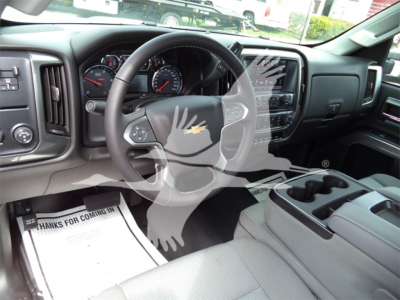 Inside view of a Chevrolet Silverado 6500HD truck cab showing steering wheel, dashboard, and center console. Visible text includes 'Chevrolet' emblem on steering wheel and vehicle controls.
