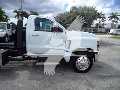 Truck cab of a 2023 Chevrolet Silverado 6500hd with rollback equipment and side mirror visible.