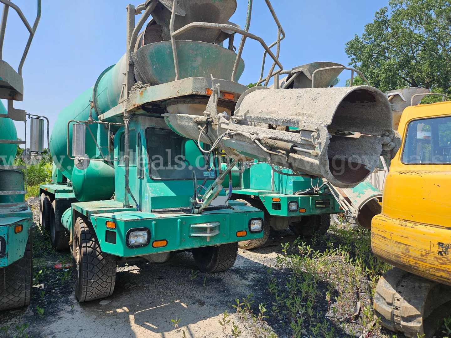 Mixer truck rear view showing concrete chute and green cab, Oshkosh S2346 style