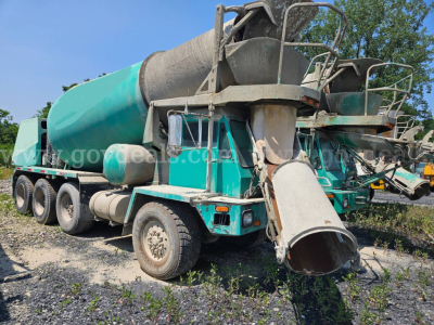 Mixer truck with green/teal body and cement chute, rear view showing large drum and dual rear wheels, concrete mixer equipment.