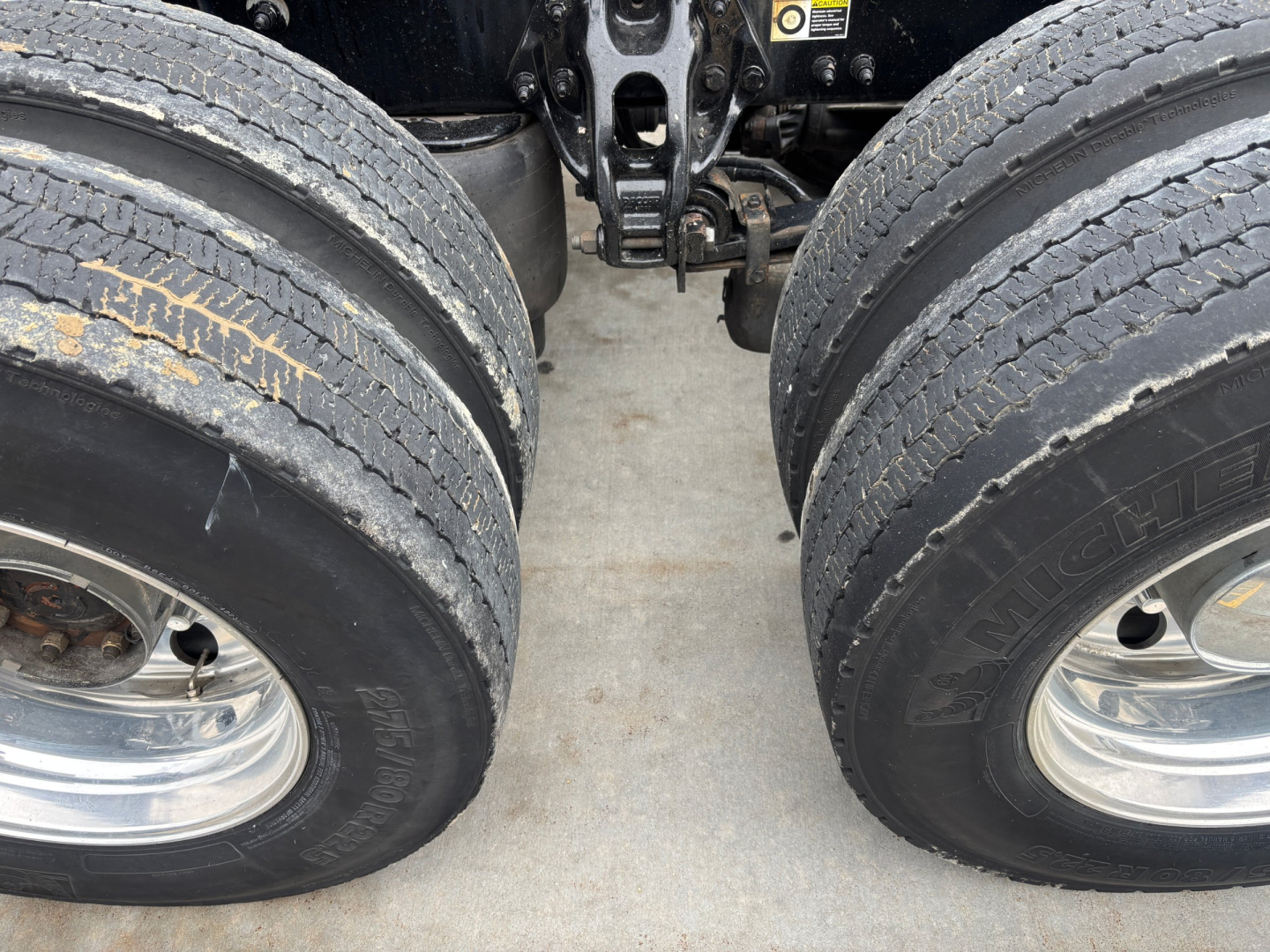 Peterbilt 579 front dual rear axles tires view showing tandem axle, rear suspension, and exhaust components.