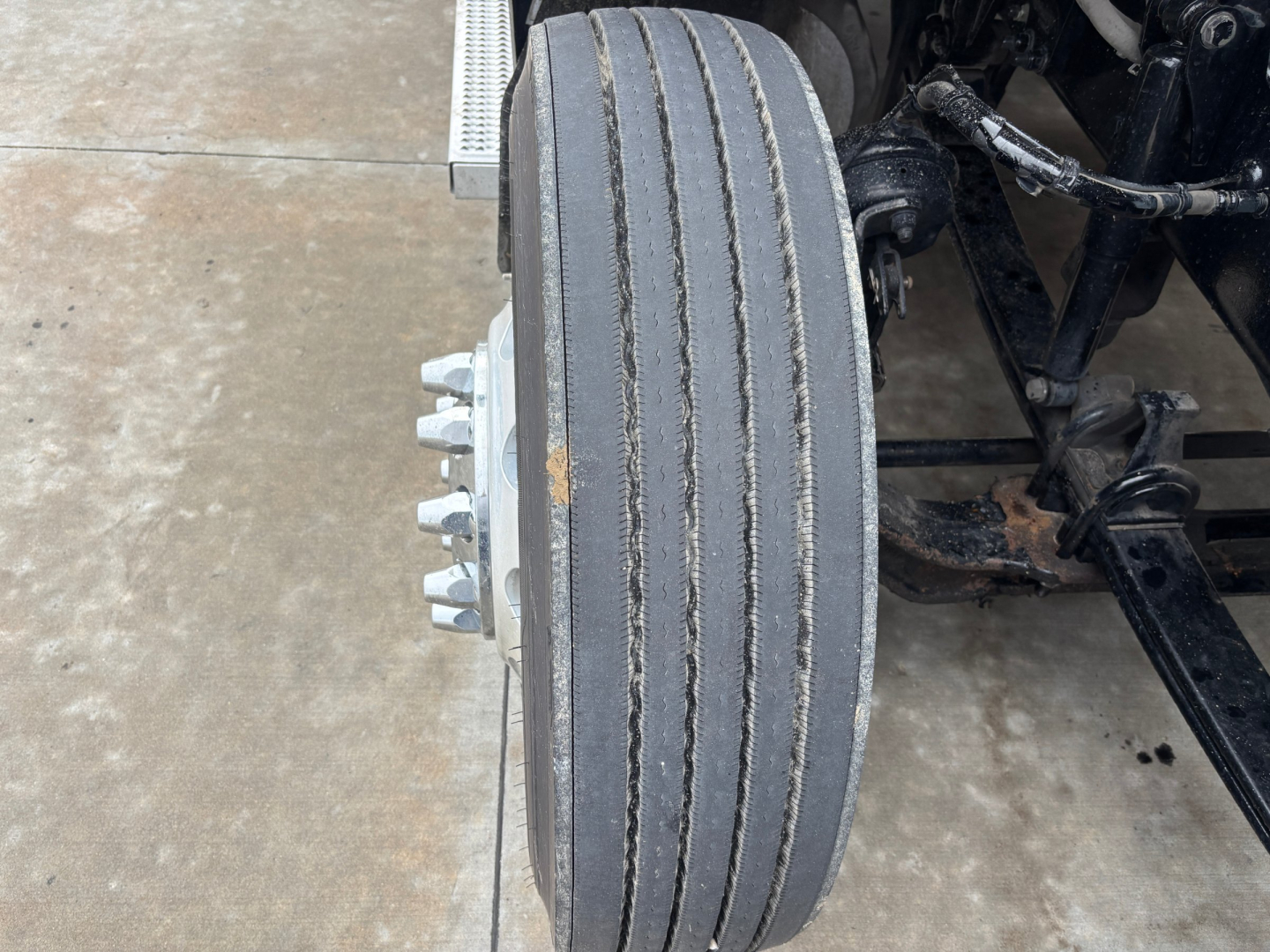 Peterbilt 579 front wheel and suspension view showing dual rear axles and wheel hub nuts.