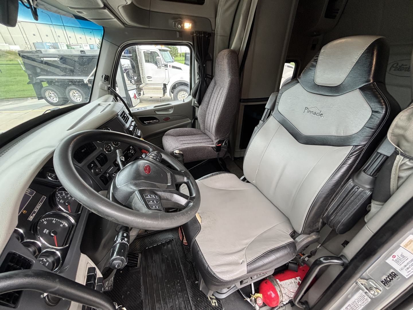 Peterbilt 579 truck cab interior showing driver seat and dashboard with steering wheel and controls.