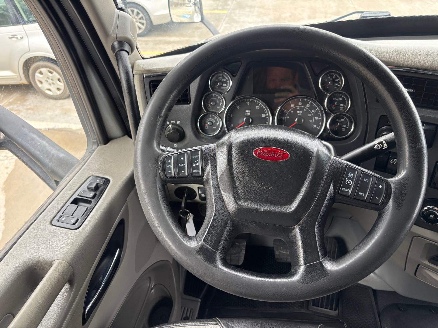 Peterbilt 579 interior view showing steering wheel with Peterbilt emblem and instrument cluster; dashboard controls visible