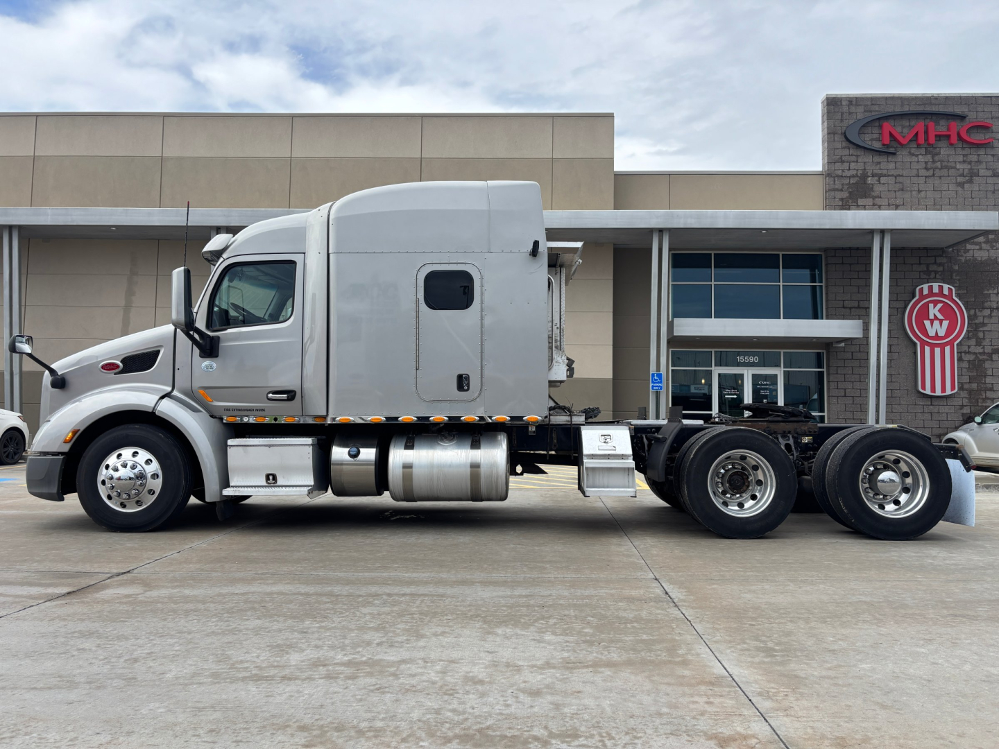 Peterbilt 579 tractor in side view showing sleeper cab, fuel tanks, and fifth wheel with triple rear axles.