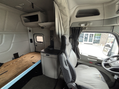 Truck cabin interior of a 2020 Peterbilt 579 sleeper with bunk bed, cabinetry, and driver's seat visible.