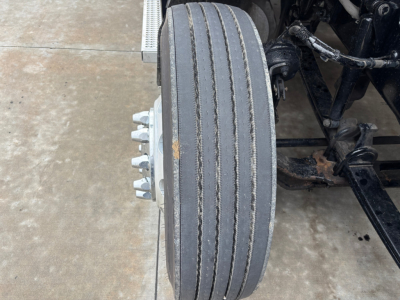Peterbilt 579 front wheel and suspension view showing dual rear axles and wheel hub nuts.