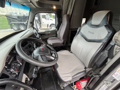 Peterbilt 579 truck cab interior showing driver seat and dashboard with steering wheel and controls.