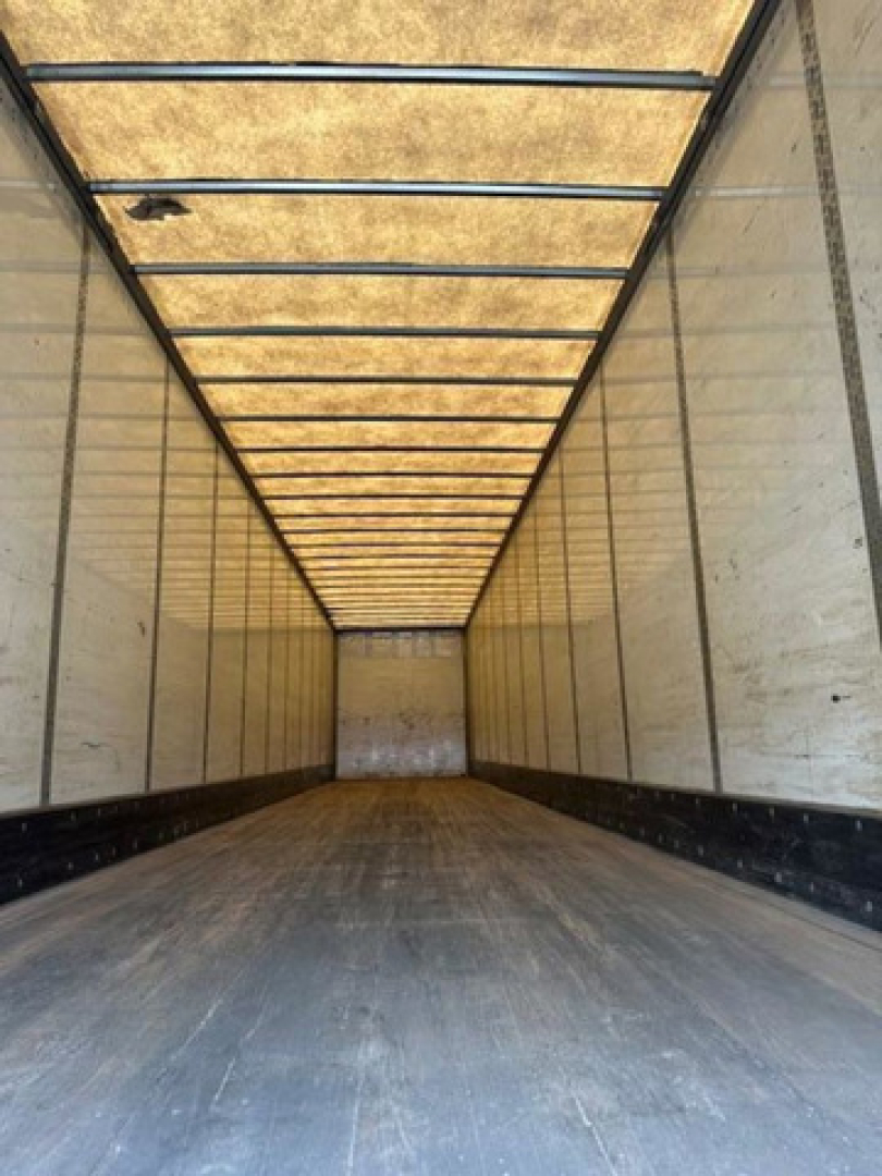 Interior of a Wabash trailer cargo area showing long empty box with wooden ceiling panels and striped metal sidewalls.