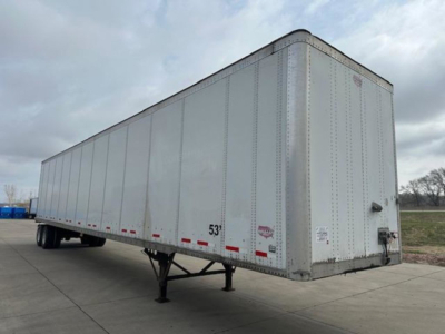 Trailer exterior showing a large silver box trailer with a raised nose, support legs down, and rear entry door. Visible text includes a small label near the bottom front corner and a height marker reading 53'.