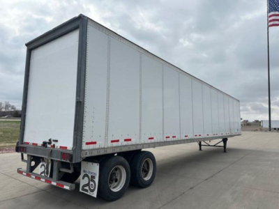 Trailer side view of a 2014 Wabash van trailer with dual rear axles and white sides, visible stock plate and rear bumper details.