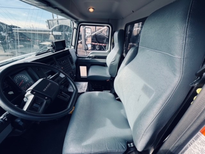 Interior of a 2025 Mack MD6 truck cab showing driver seat and dashboard with steering wheel and side window.