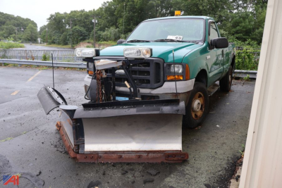 Ford F-250 Super Duty pickup truck with snow plow attachment front view showing green body and black plow blade.