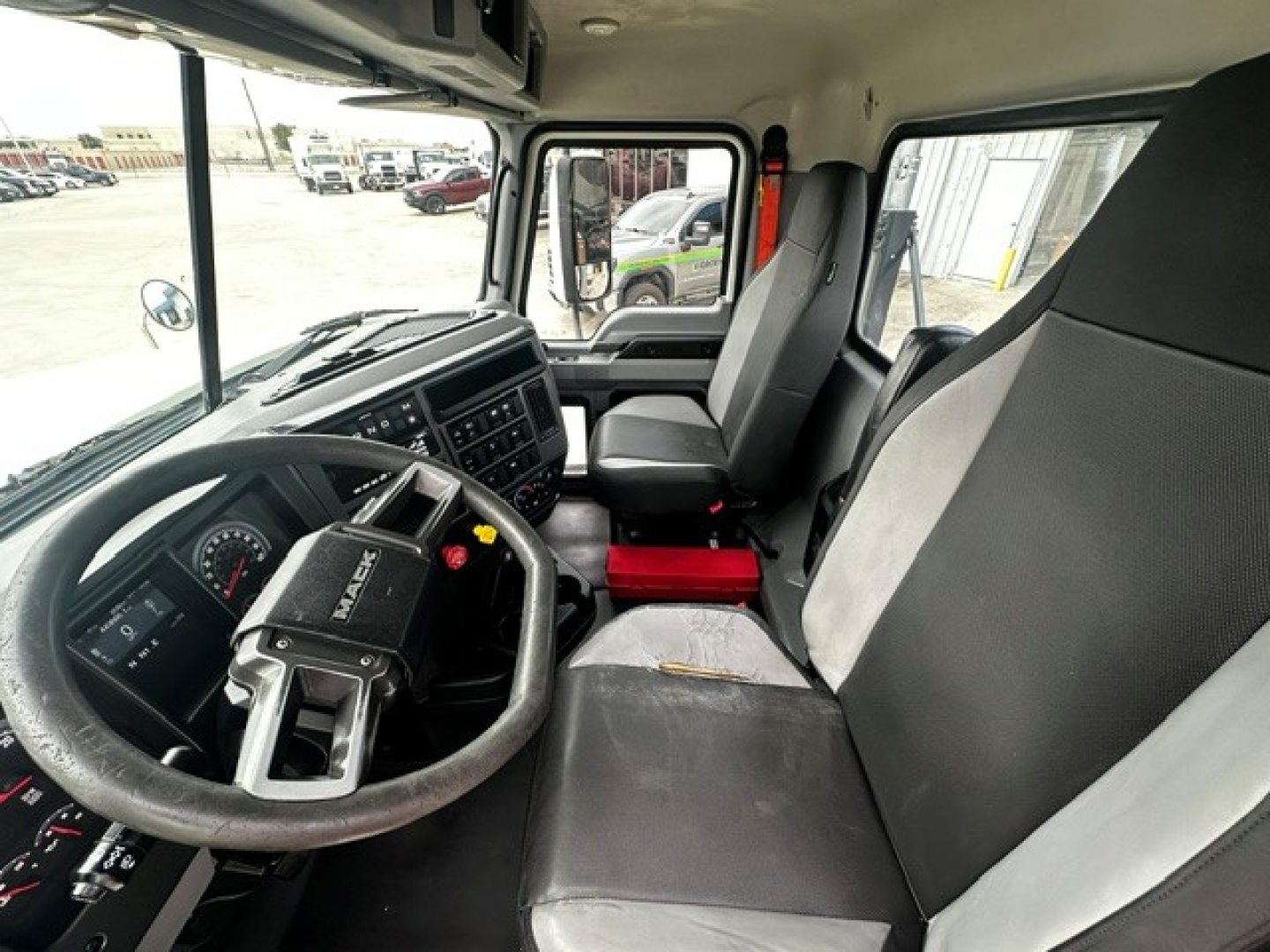 Interior of a 2020 Mack PI64T truck cab showing steering wheel, dashboard, driver seat, and passenger seat.