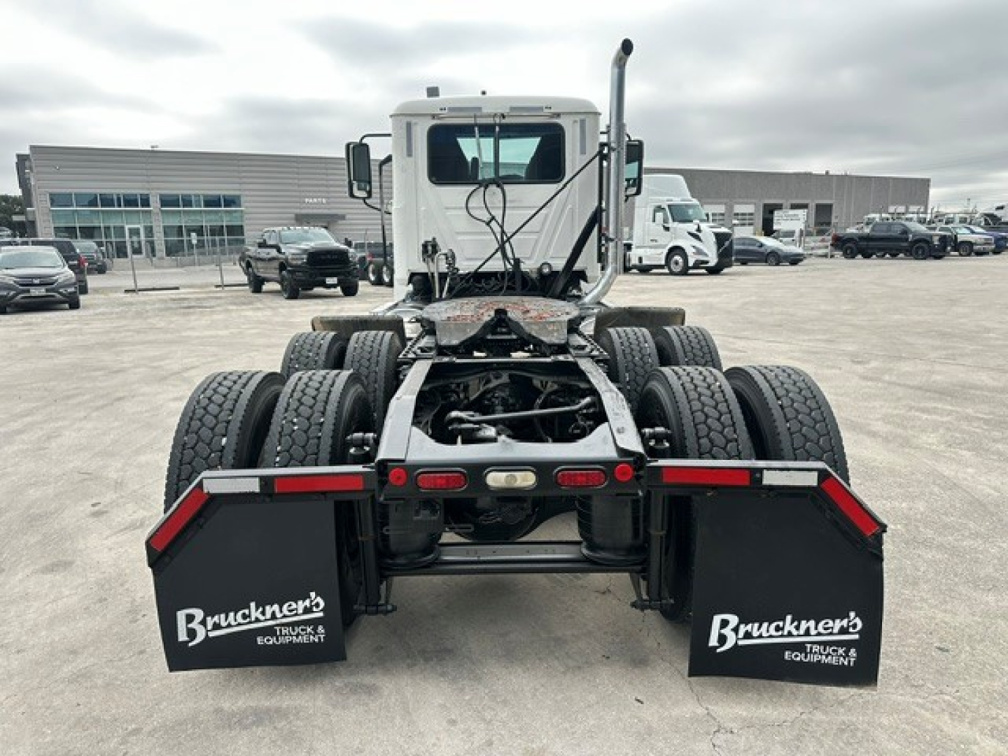 Rear view of a 2020 Mack PI64T conventional daycab tractor showing dual rear axles, mud flaps with Bruckner’s Truck Equipment branding, and tire racks.