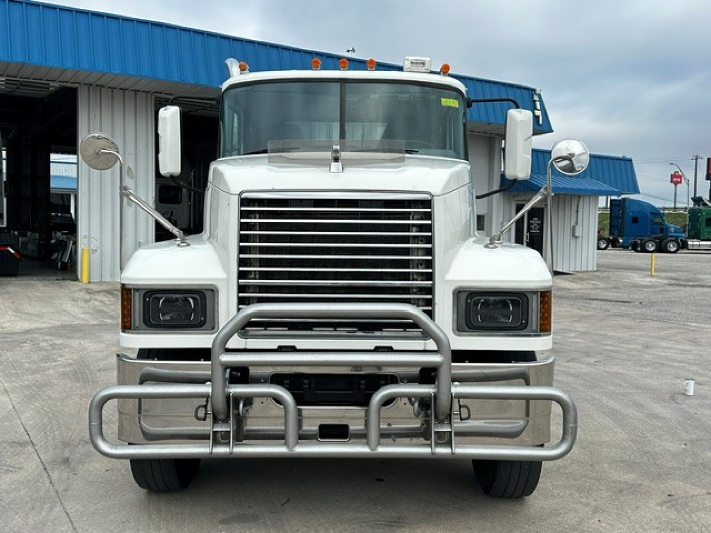 Front view of a white 2020 Mack PI64T conventional daycab truck with a tubular grille guard and large bumper, two rectangular headlights, and side mirrors.