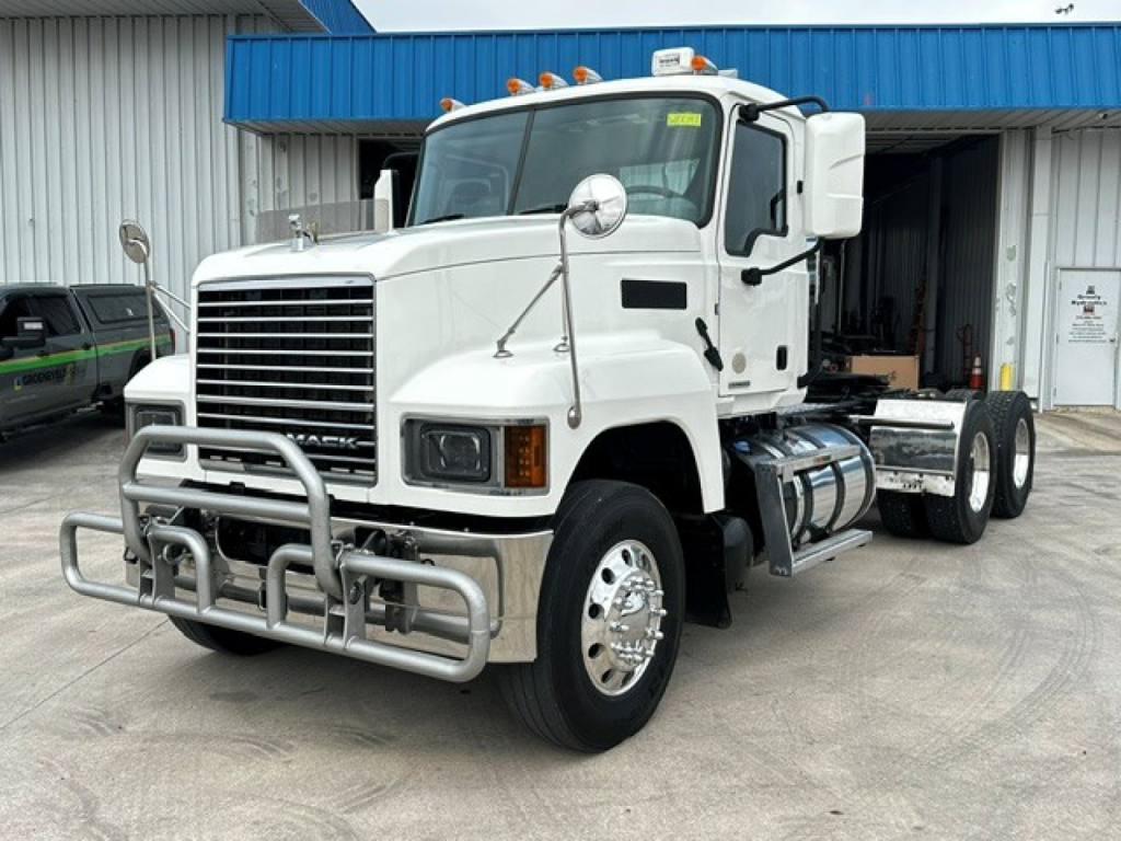 Front-left view of a white 2020 Mack PI64T conventional daycab truck with a chrome bumper guard, large grille, dual round mirrors, and fuel tanks visible.