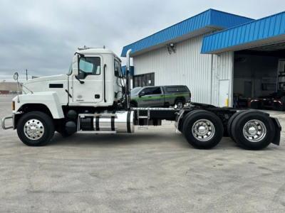 Mack PI64T conventional daycab truck side view showing front cab, chassis, and dual rear axles with chrome fuel tanks.