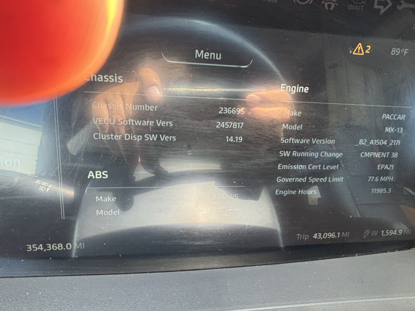 Kenworth T680 dashboard display showing Vehicle ECU details and software versions with menus and numeric readouts.