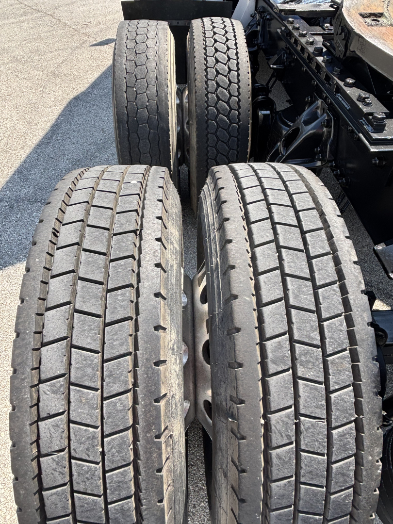 Kenworth T680 axle area showing dual rear tires and tread patterns with visible frame and suspension components.