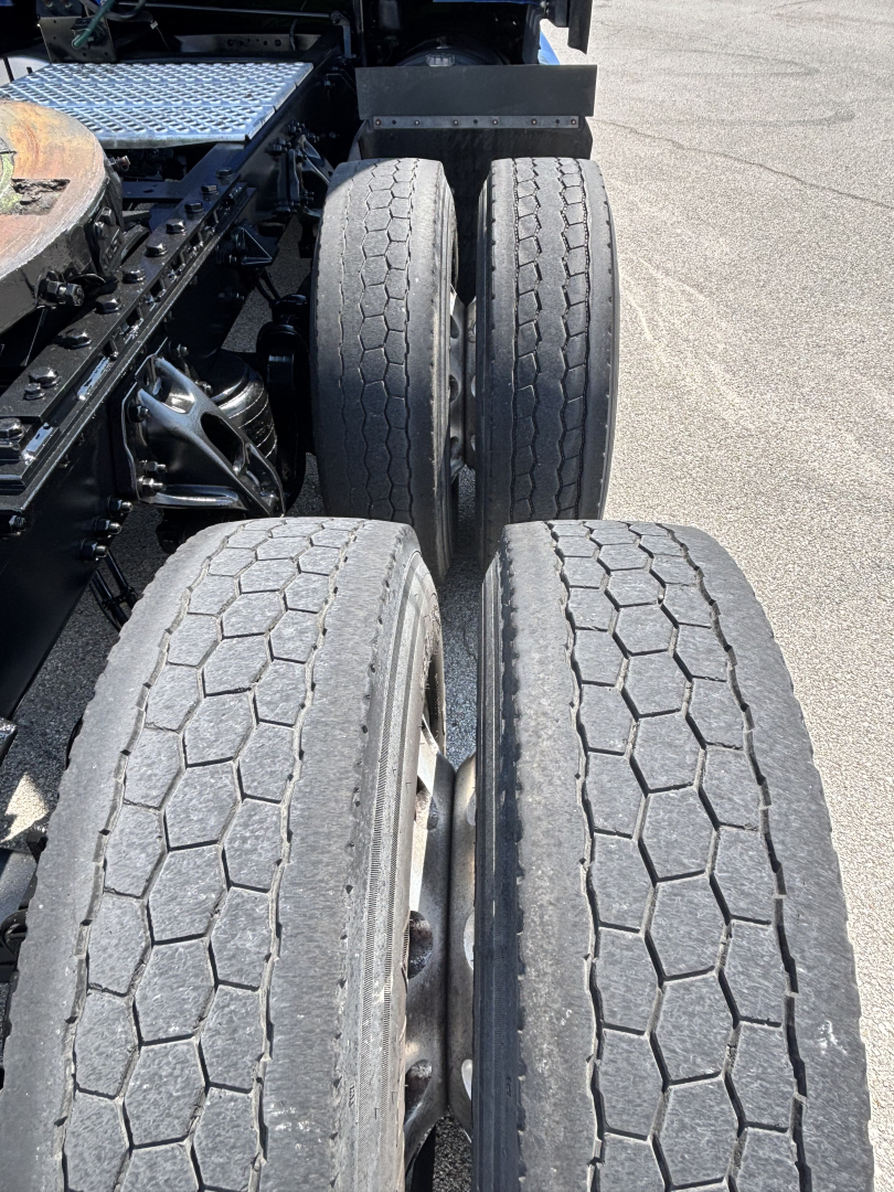 Kenworth T680 rear axle area showing dual tandem tires with tread pattern visible.