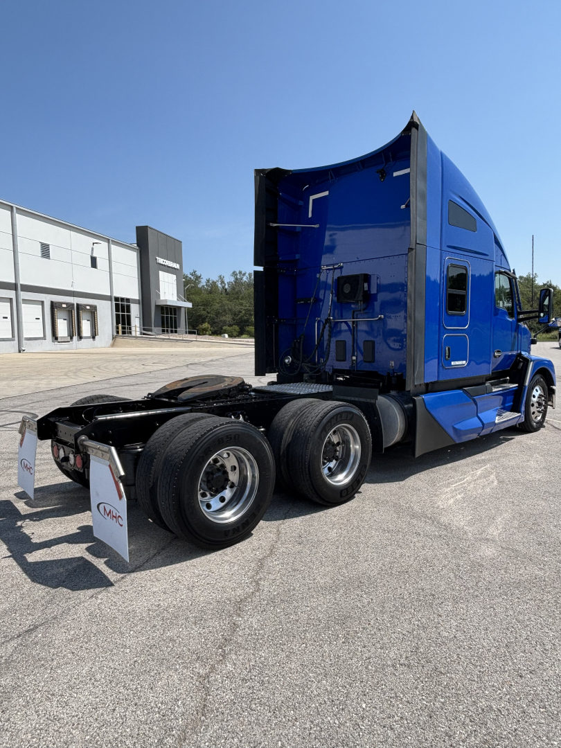Kenworth T680 tractor in blue, side/rear view showing sleeper cab and dual rear axles with fifth wheel, no visible text on image.
