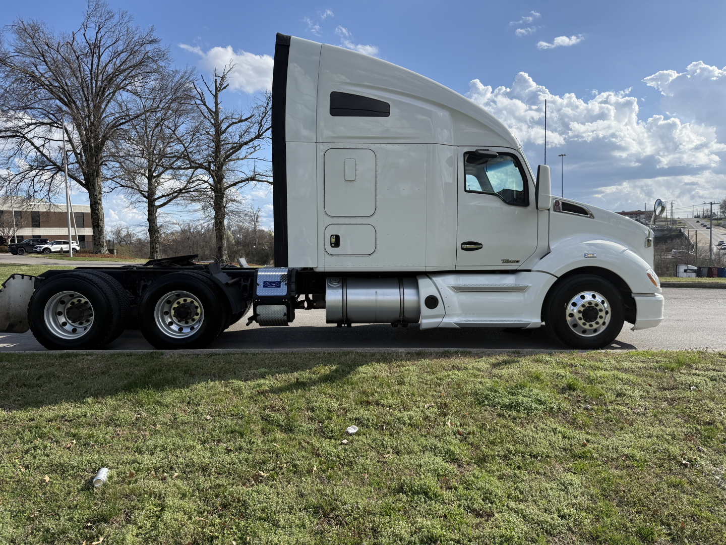 Kenworth T680 sleeper cab tractor in profile view showing side tanks, wheels, and exhaust, with no text visible