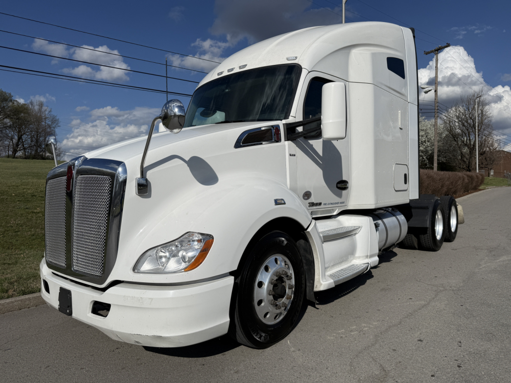 Kenworth T680 conventional sleeper truck in white, front three-quarter view showing cab and aerodynamic design, star mirror, and chrome grille.