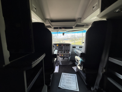 Cabin view of a 2021 Kenworth T680 truck interior with dashboard, steering wheel, and overhead storage compartments visible.