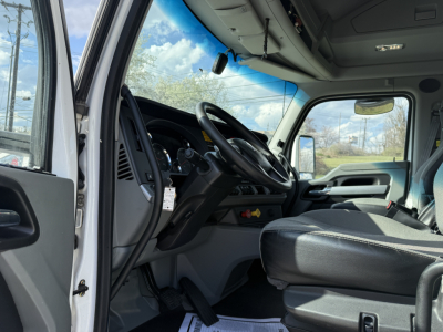 Kenworth T680 truck cab interior from open door, steering wheel, dashboard, and driver seat visible.
