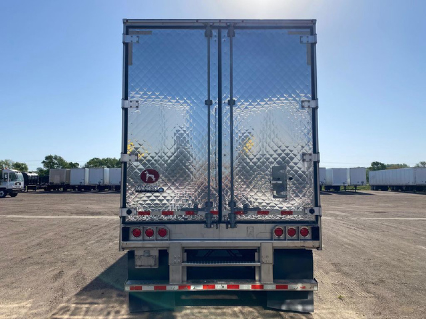 Rear view of a 2020 Great Dane refrigerated trailer with diamond-plate doors, rear lights, and use reflected in chrome surface.