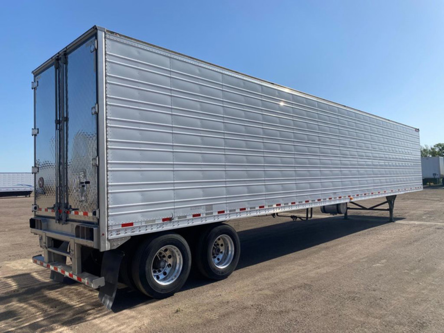 Great Dane reefer trailer side view showing tandem axles and rear double doors.