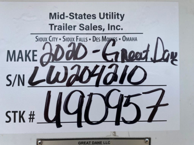 Mid-States Utility Trailer Sales sign with handwritten VIN, S/N, and stock number. Printed header reads 'Mid-States Utility Trailer Sales, Inc.' with locations Sioux City, Sioux Falls, Des Moines, Omaha. Handwritten text includes 'MAKE' fol