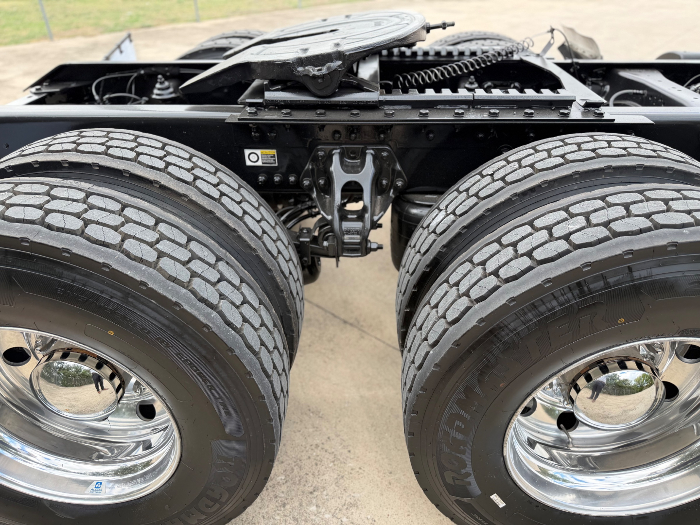 Kenworth T880 chassis section showing dual rear axles and tandem drive wheels with chrome rims and tire treads.