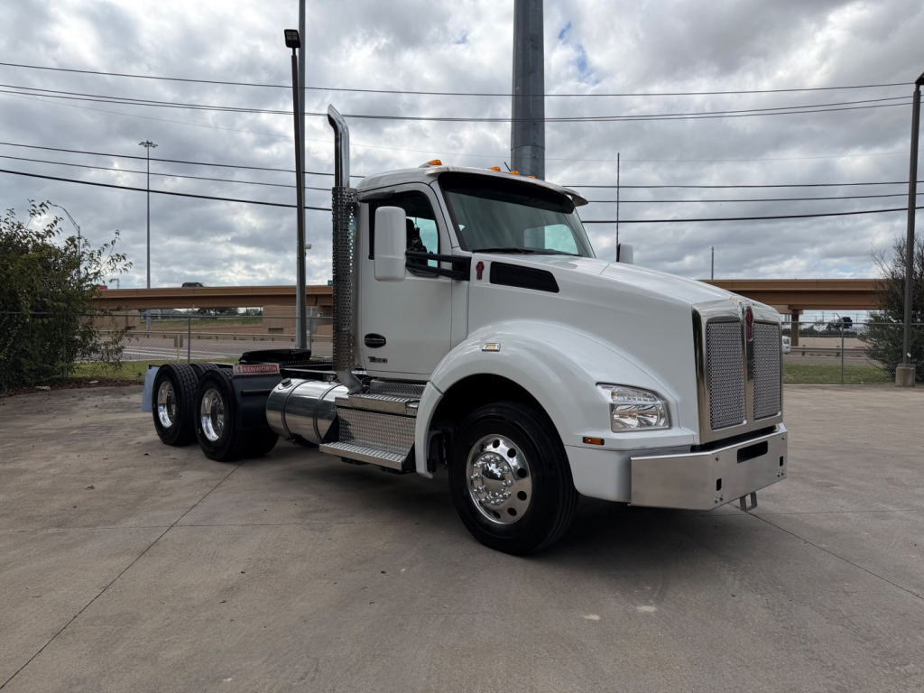 Kenworth T880 conventional daycab truck in white, side view showing front grille, cab, sleeper area, dual rear axles, and chrome bumper.