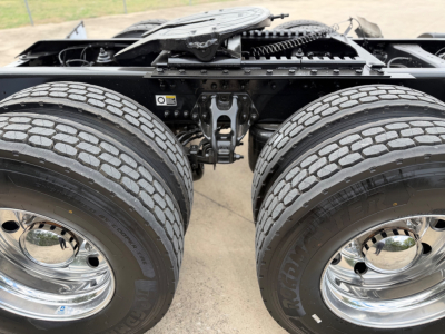 Dual rear axles on a Kenworth truck chassis showing tires, rims, and suspension components.