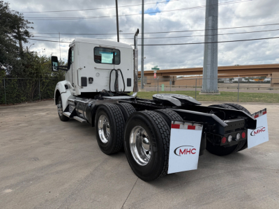 Kenworth T880 tractor rear and side view showing dual rear axles, fifth wheel, fuel tanks, and MHC white mud flaps.