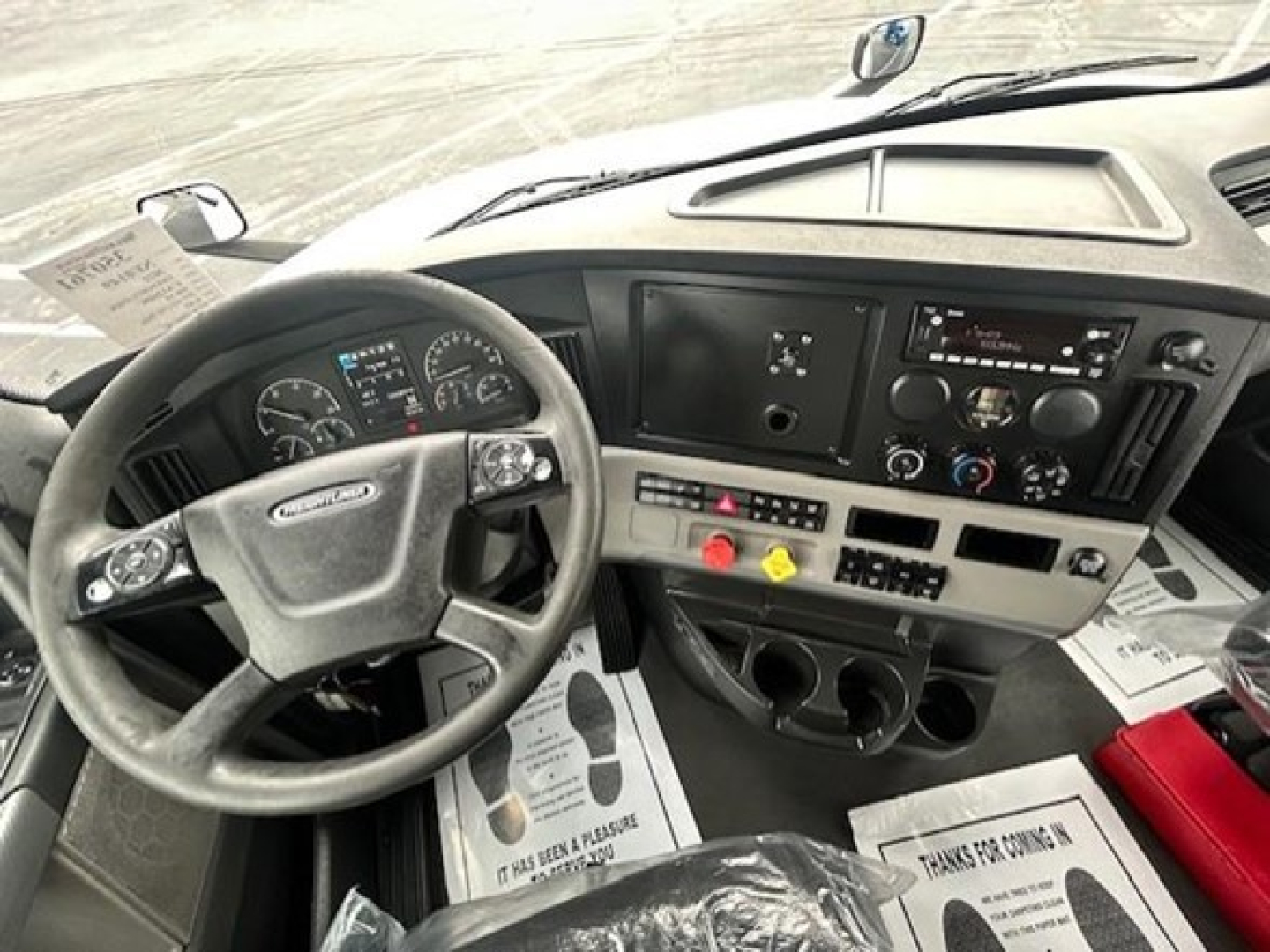 Dashboard and steering wheel of a Freightliner Cascadia 126 cab showing instrument cluster and center console with controls.