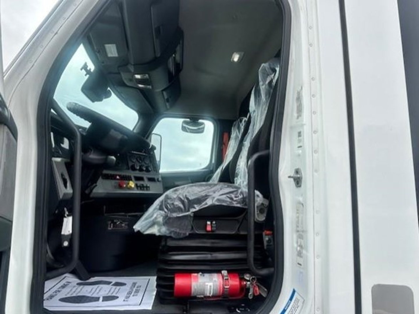 Truck cab interior of a 2022 Freightliner Cascadia 126 day cab showing driver seat and dashboard