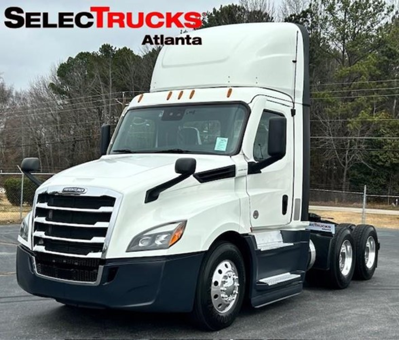 Semi truck cab and chassis of a 2022 Freightliner Cascadia 126 in white with black bumper and wheel wells, shown in dealership lot with SelecTrucks Atlanta branding.