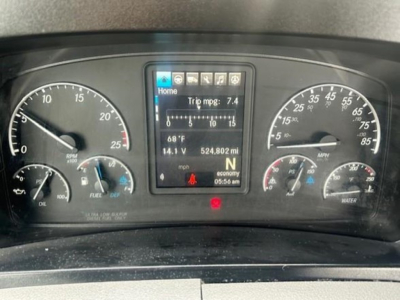 Dashboard of a 2022 Freightliner Cascadia 126 showing instrument cluster and center screen with trip mpg 7.4 and various gauges.