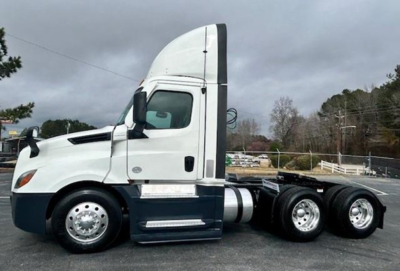 Freightliner Cascadia 126 day cab tractor in white with sleeper height, side view showing cab and rear axles.