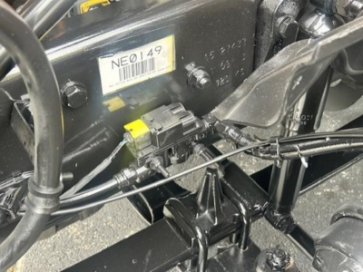 Freightliner Cascadia chassis showing electrical connector and label NE0149 with barcode.