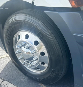 Front wheel of a 2022 Freightliner Cascadia 126 day cab showing Goodyear tire and chrome hubcap with lug nuts.
