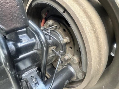 Freightliner Cascadia 126 wheel hub area showing front suspension and brake components with wires; visible text on components not legible.