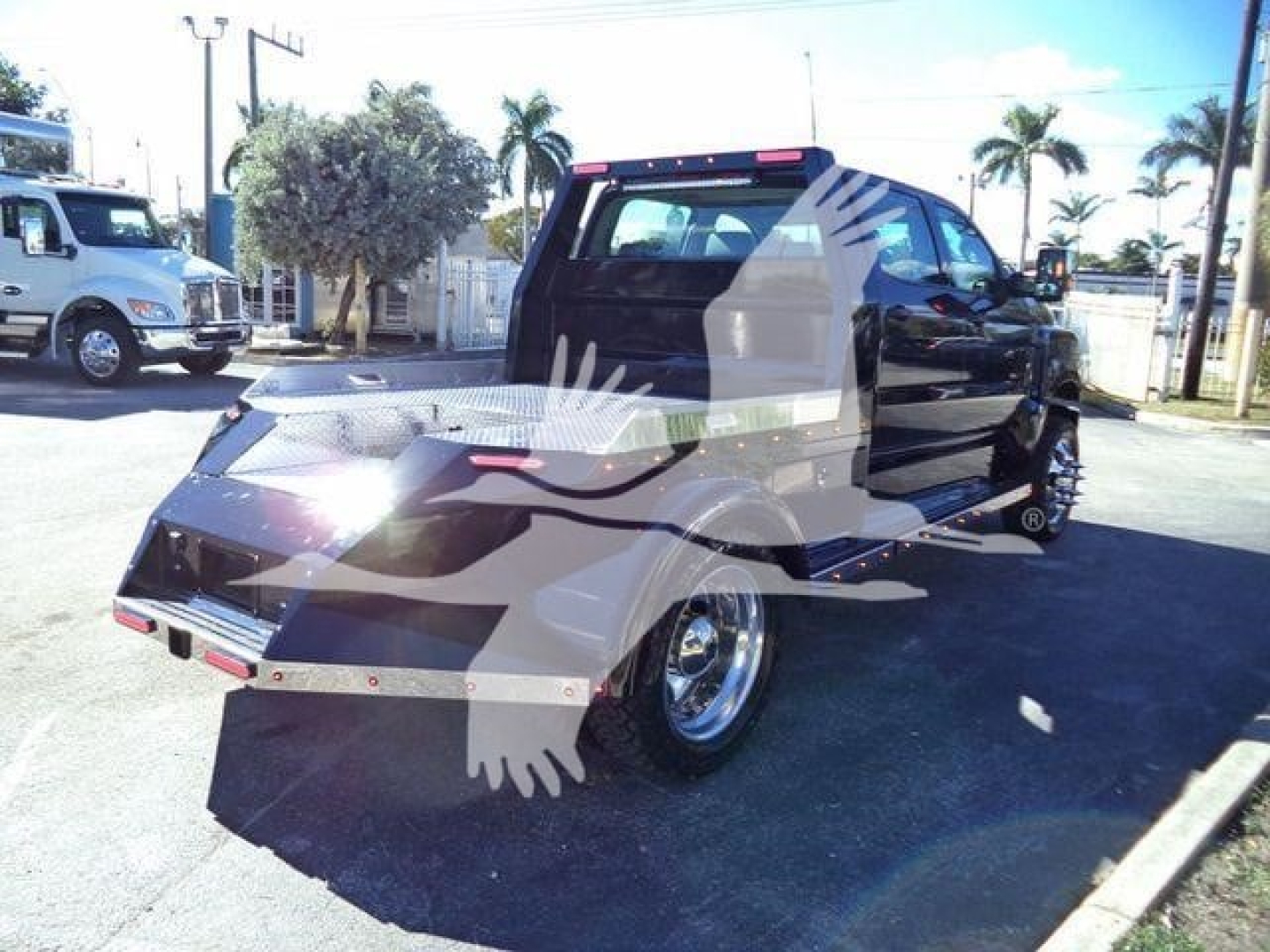 Truck bed side view shows 2023 International CV with black cab, chrome wheels, and aluminum flatbed; sticker text not visible.