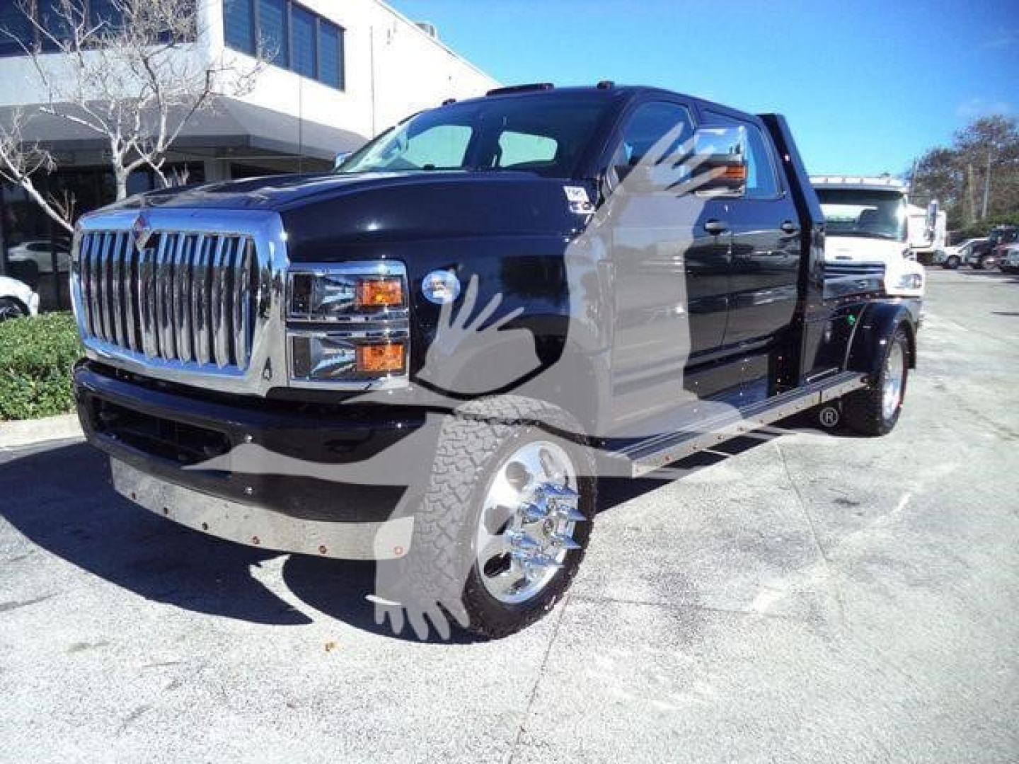 Truck showing a dark blue 2023 International CV with chrome front grille and dual rear wheels in a dealership lot.