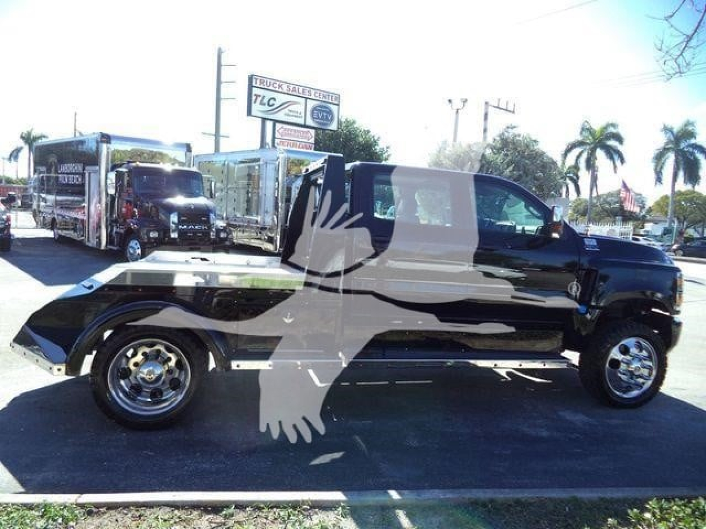 Truck bed with a black cab over a pickup, side view showing the truck on a lot